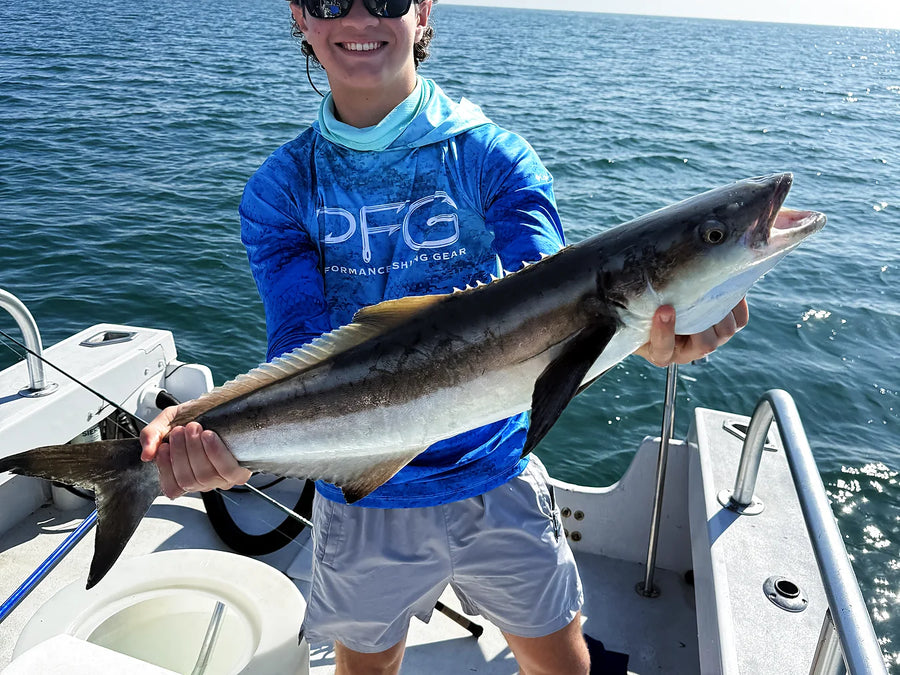 Male angler holding a fish on an offshore charter