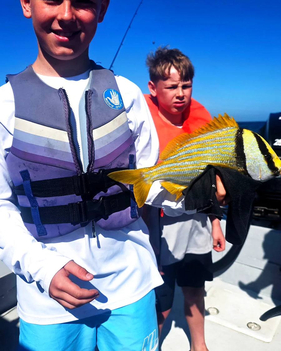 Young angler holding a catch on a family fishing trip