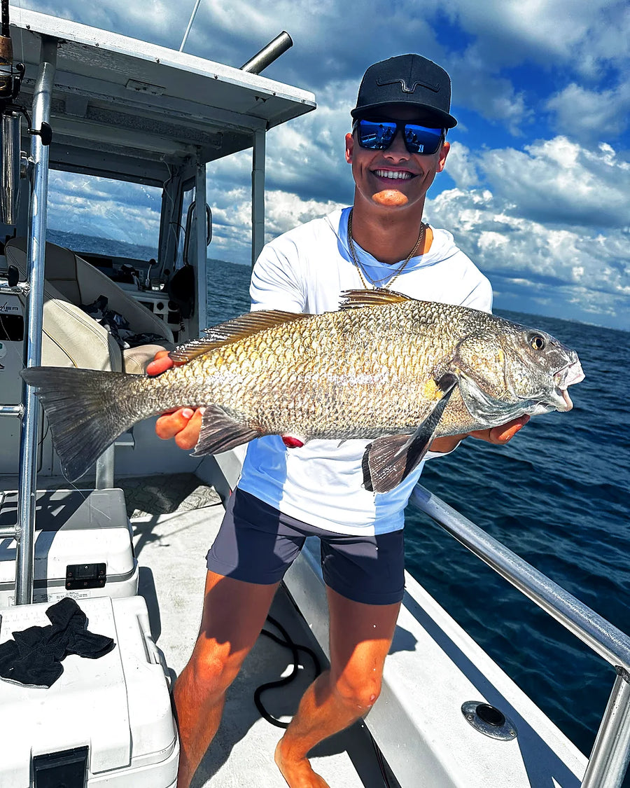 Offshore charter guest holding a large fish