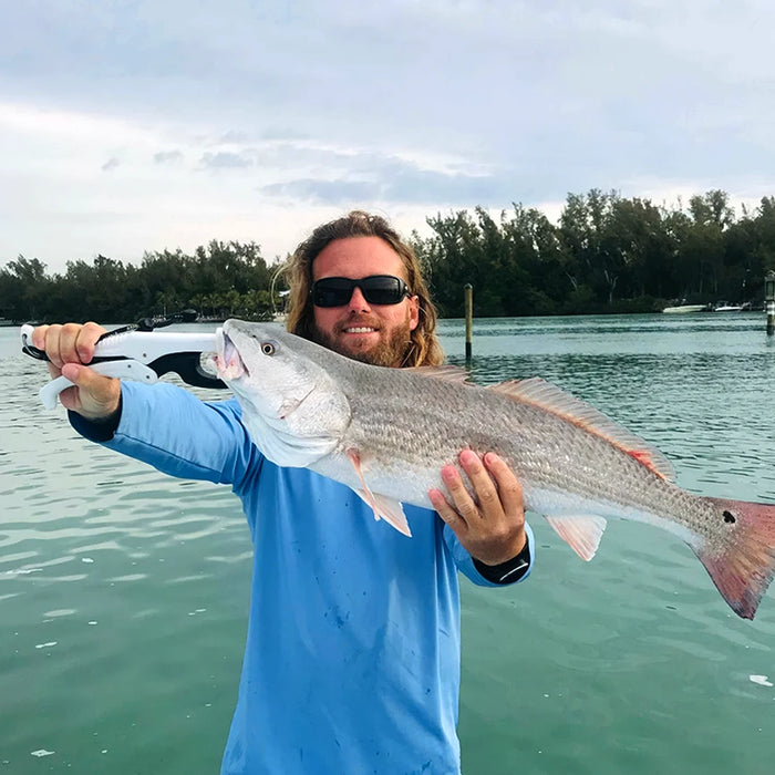 Guest holding a fish on a Sarasota fishing charter