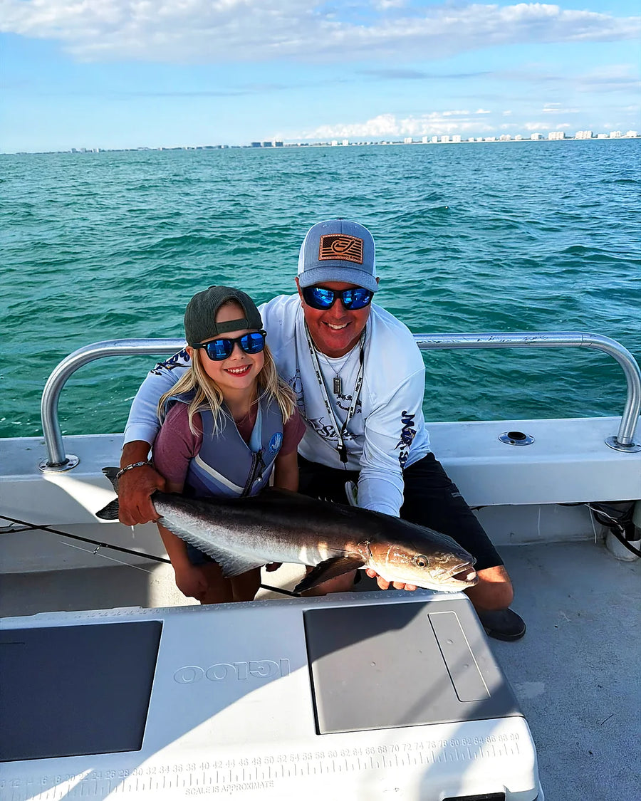 Couple smiling with a fish on a Siesta Key fishing trip